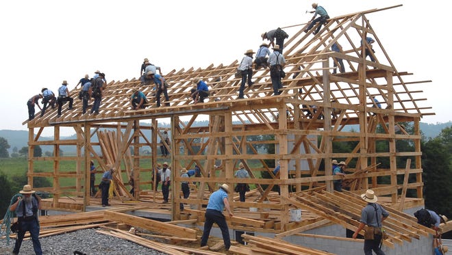 Image of Mennonites building a barn.