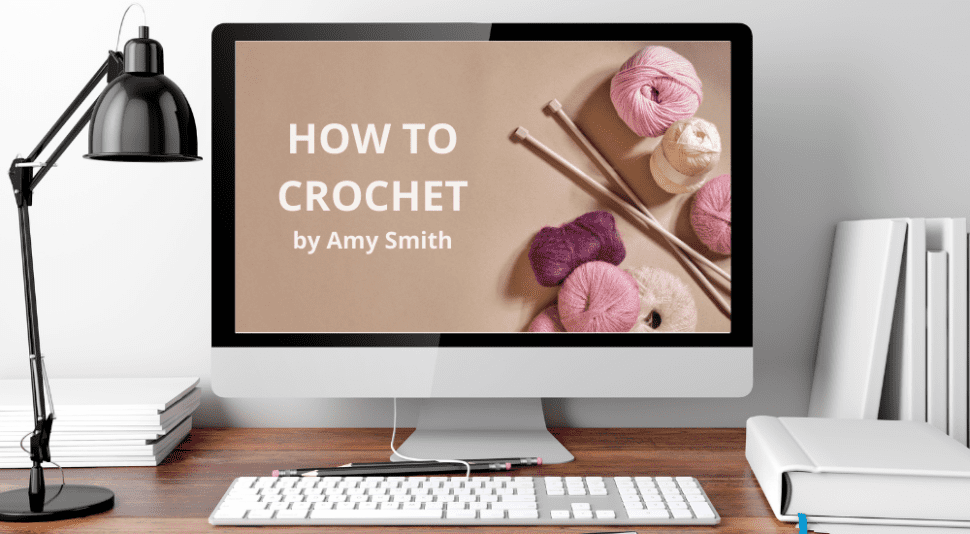 Desk with a black lamp and Mac PC with the screen showing How to Crochet.