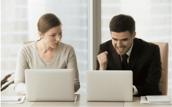 business man and woman celebrating digital marketing victory on laptops