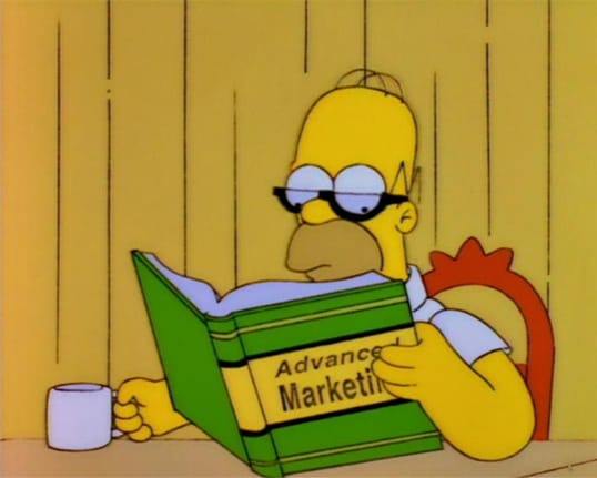 Homer Simpson reading a book called Advanced Marketing