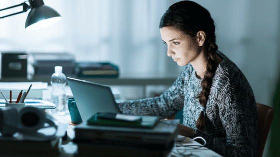 studious student studying in the dark with laptop, likely working on digital marketing