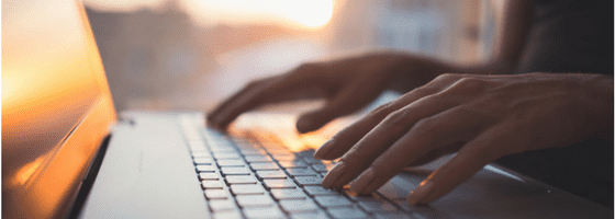 Woman copywriting on laptop in sunlight