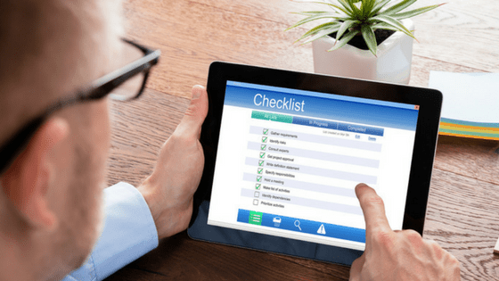 man completes a checklist that he downloaded as a lead magnet on his tablet